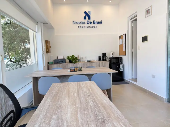 Sala de reuniones con mesa de madera y sillas